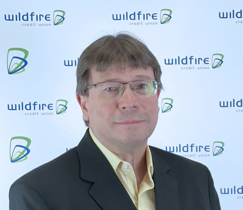 Darrell Burchfield with Wildfire Credit Union logo on white background behind him.