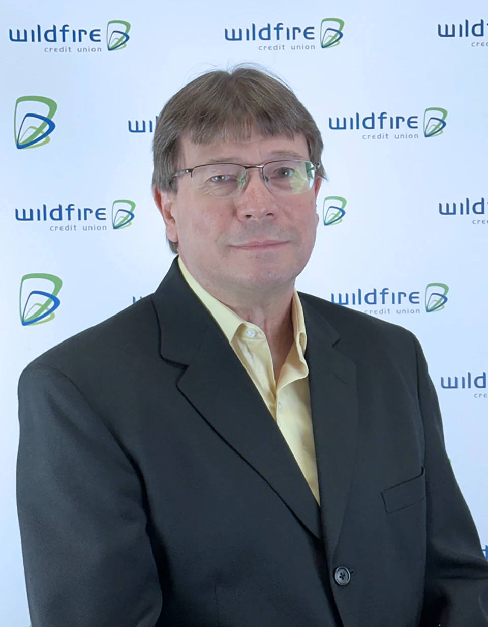 Darrell Burchfield with Wildfire Credit Union logo on white background behind him.