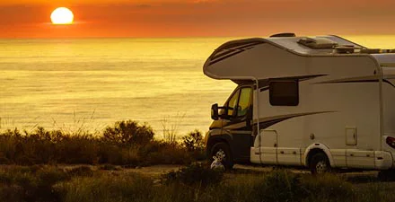RV parked by Lake Michigan at sunset, overlooking a scenic view.