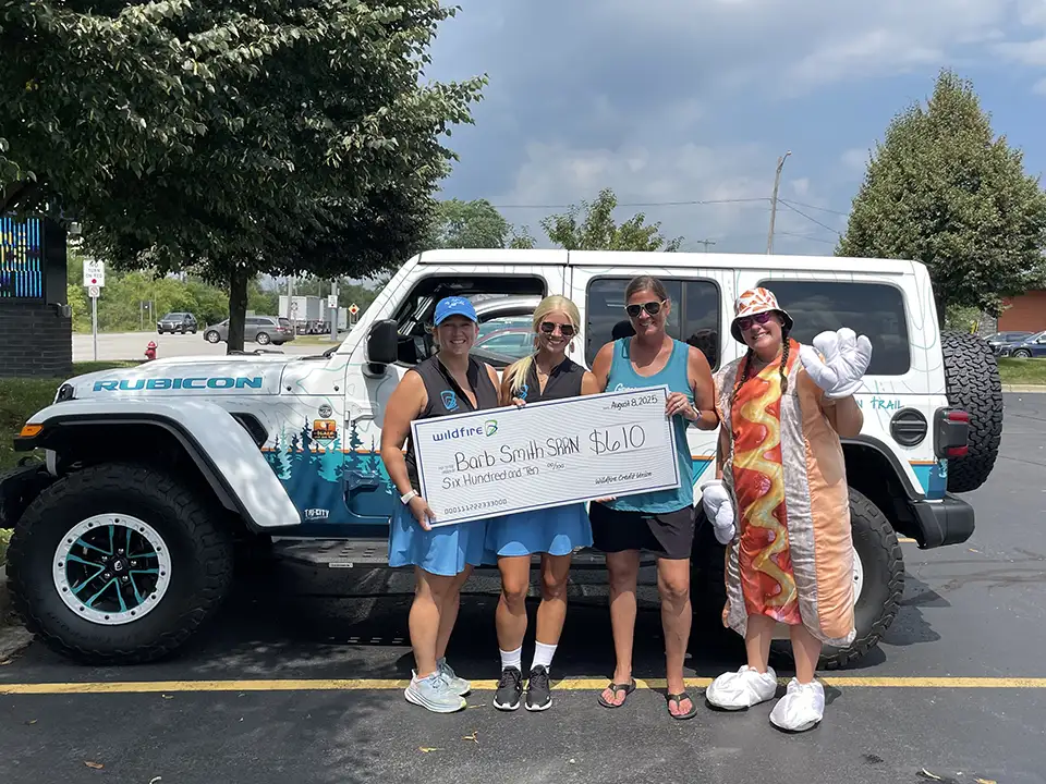 Wildfire employees in front of Jeep and one in hot dog costume present to Barb Smith Suicide Resource & Response Network