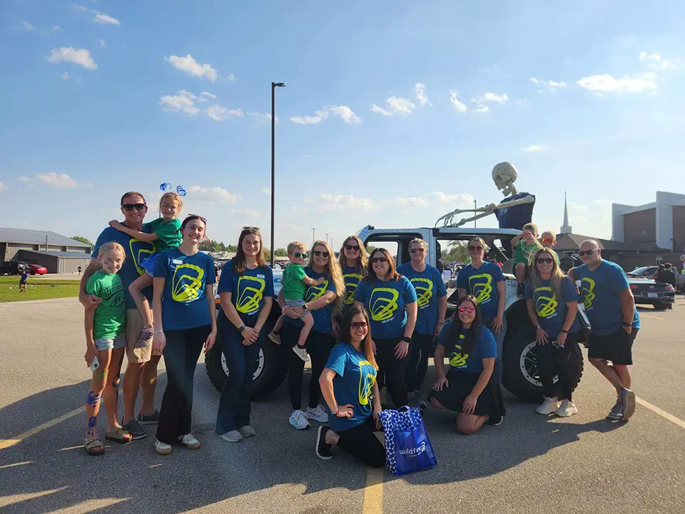 Wildfire employees stand outside of Wildfire Jeep on sunny Saginaw day before parade.