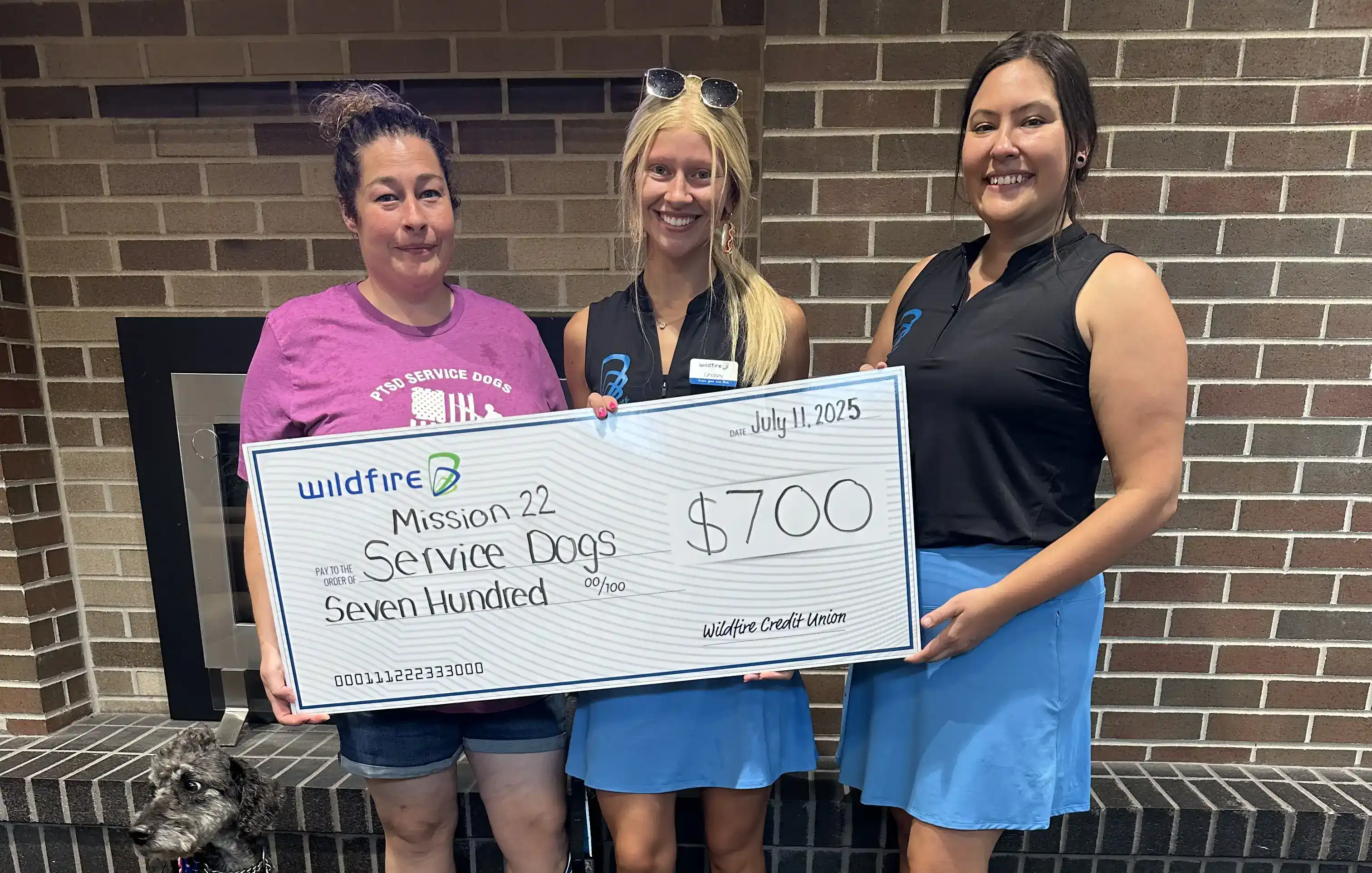 Two Wildfire employees present check to Mission 22 Service Dogs.