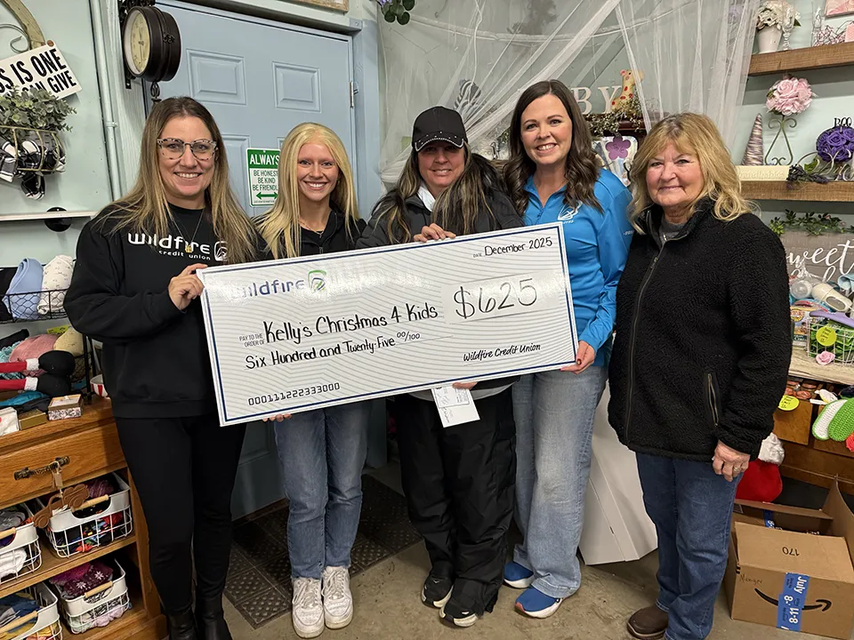 Three Wildfire employees present a check to The Caring Closet for Kelly's Christmas 4 Kids.