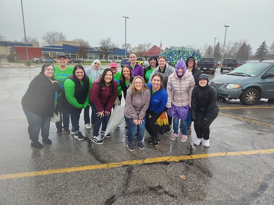 Wildfire team smiling and volunterring at Saginaw YMCA in the rain.