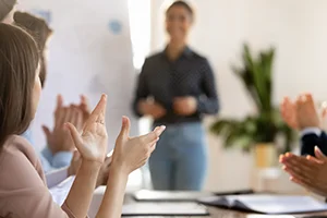 Audience clapping for a presenter during a meeting or workshop.