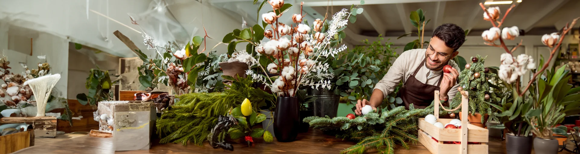 Man working at business store selling winter floral arrangements.